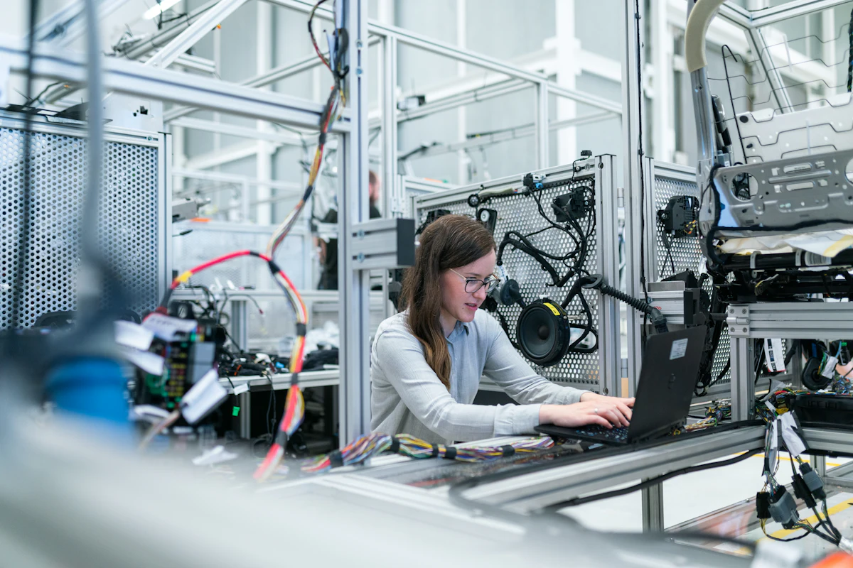 Inspector measuring a printed sheet with a caliper at a production bench